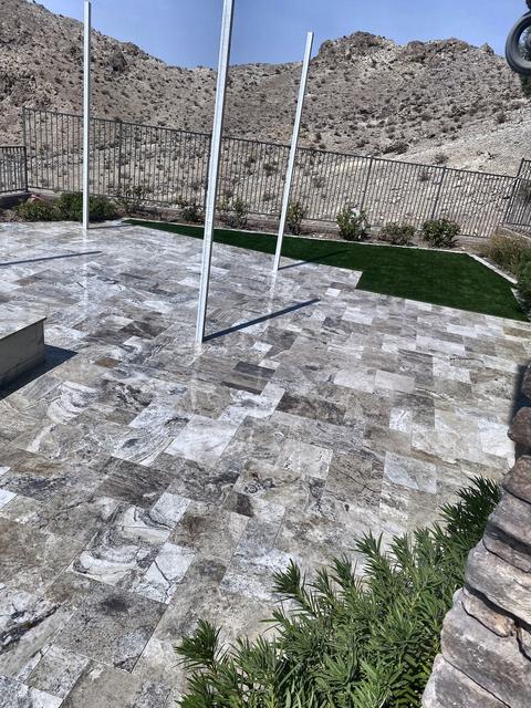 Travertine patio at the fence line, a Unique Pavers job in Las Vegas Valley