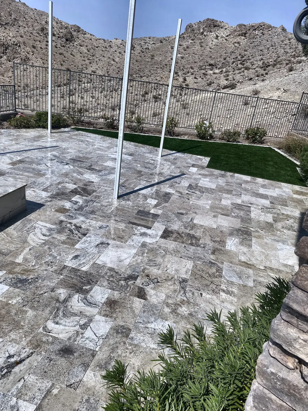 Travertine patio at the fence line, a Unique Pavers job in the Las Vegas valley