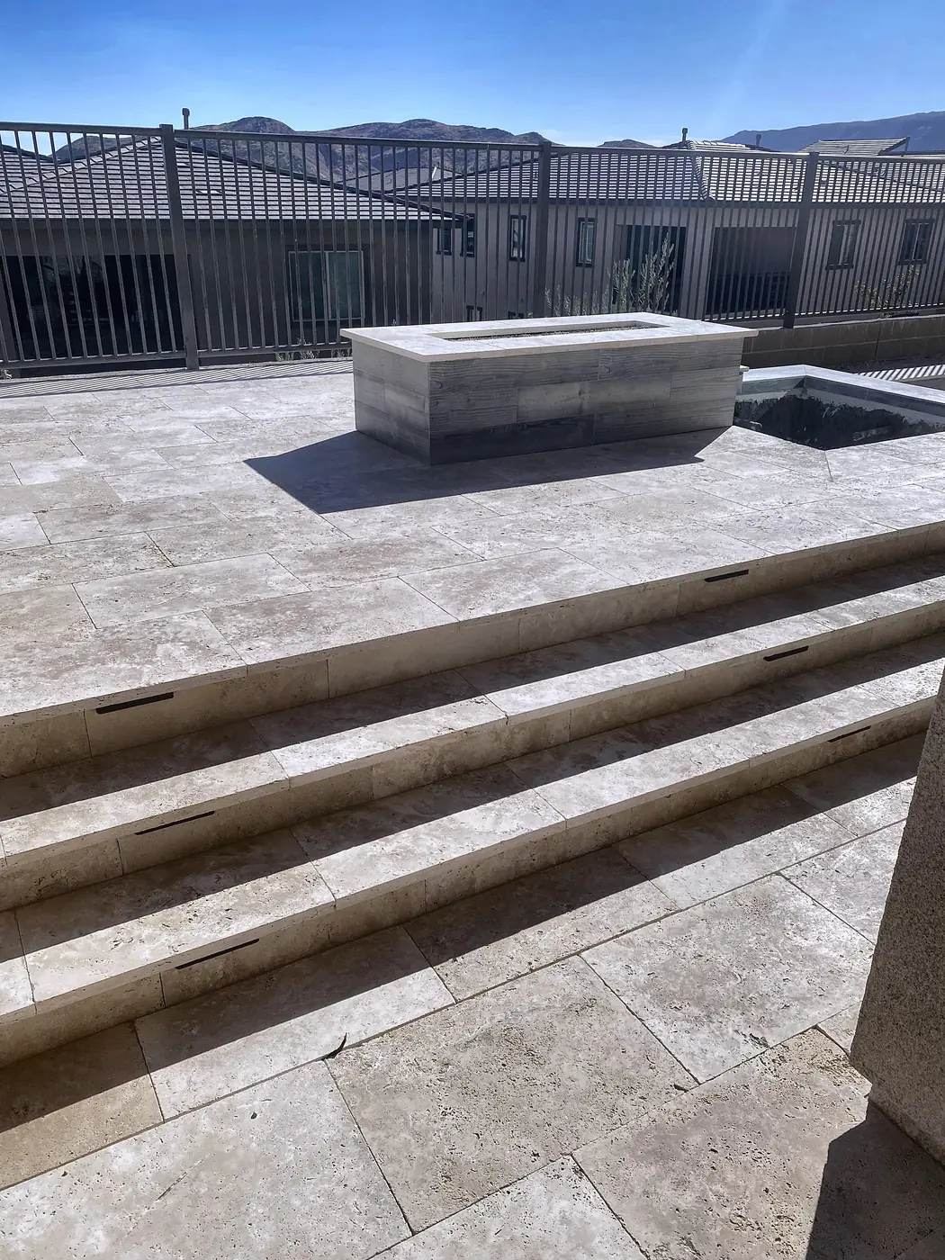 Fire pit on a travertine terrace, a Unique Pavers job in the Las Vegas valley