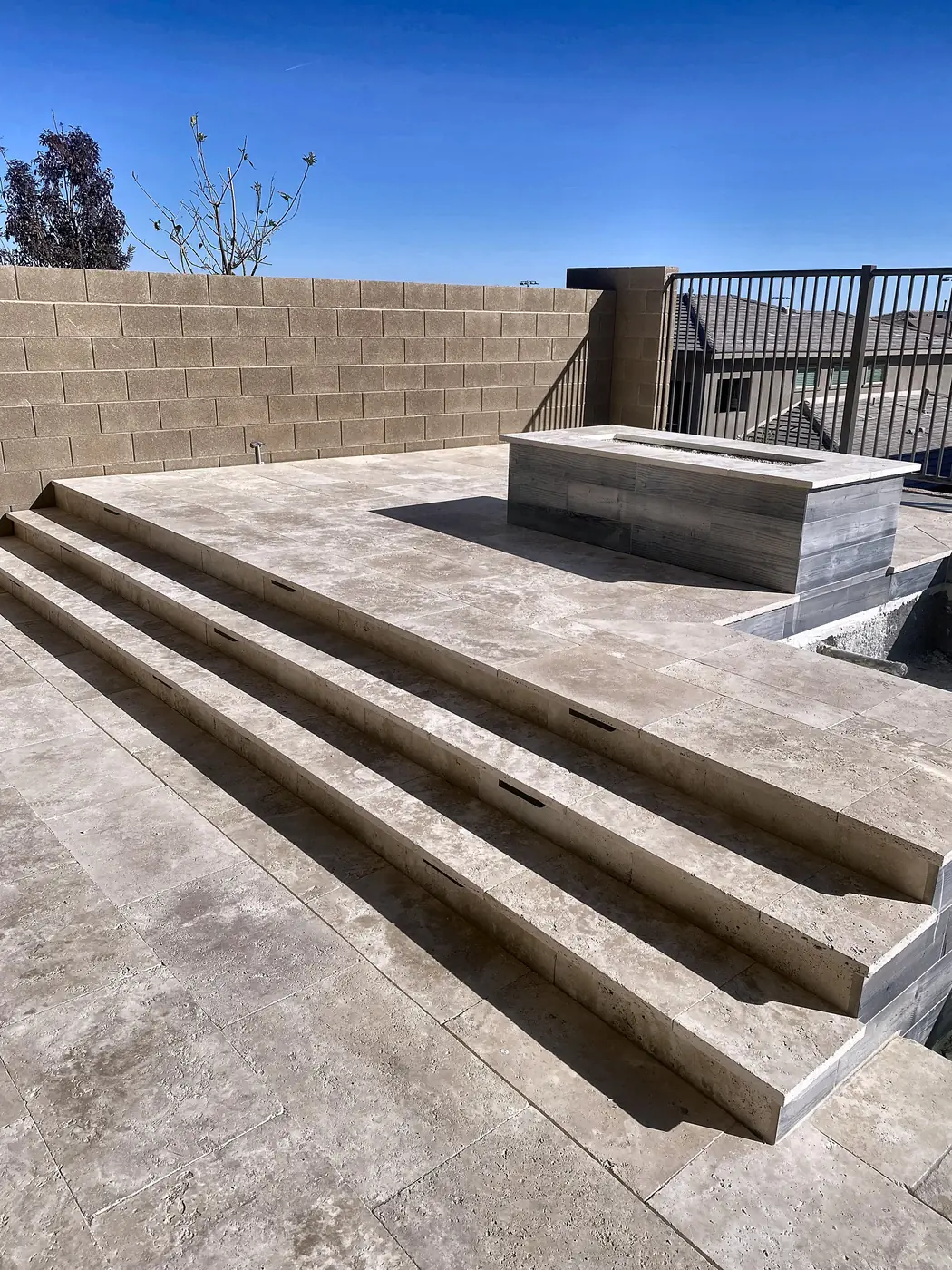 Travertine patio with fire pit and steps, a Unique Pavers job in the Las Vegas valley