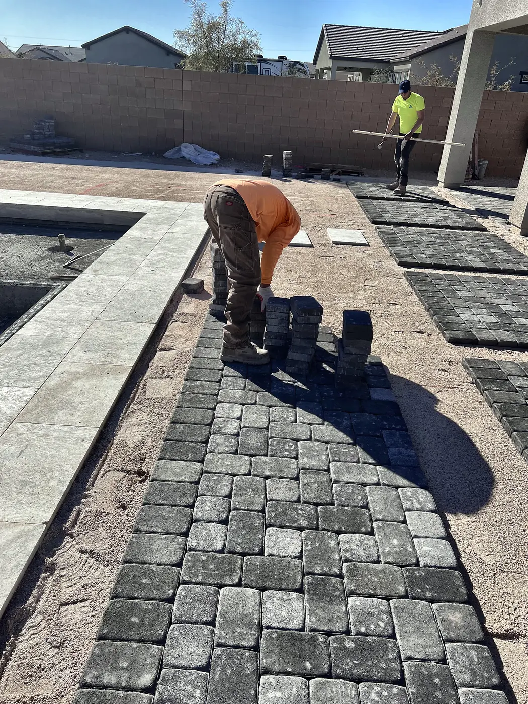 Setting pavers on the sand bed, a Unique Pavers job in the Las Vegas valley
